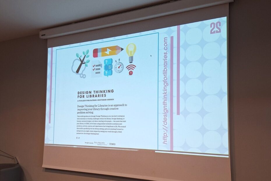 Projektor, ki projecira powerpoint za delavnico Design thinking ofr libraries. slika prikazuje platno, kjer je opis oblikovalskega razmišljanja.